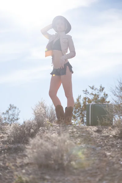砂漠でスーツケースを持って歩く女性旅行者 — ストック写真