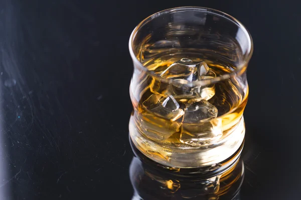 Whisky sulle rocce sul tavolo di vetro — Foto Stock