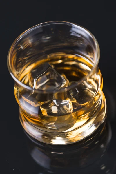 Виски со льдом на стеклянном столе — стоковое фото