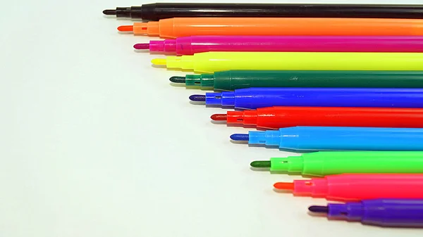 multicolored markers on white background
