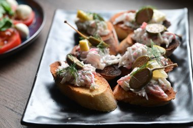 Domates, peynir ve jambonlu bruschetta..