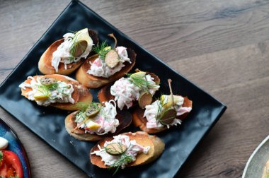 Peynirli bruschetta, otlar, zeytinler, sarımsak, otlar, yağ, sarımsak.