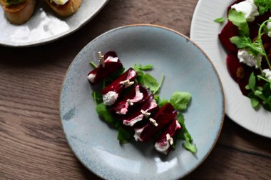 Lezzetli taze salata roka, roka, tabakta ceviz ve peynir, yakın plan.