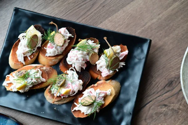 Lezzetli bruschetta kremalı ve somonlu siyah tabakta..