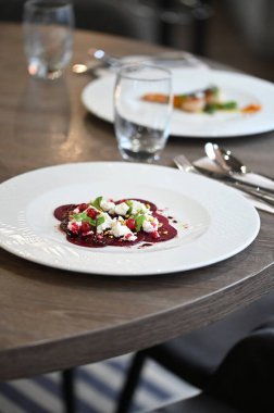 Kızarmış kırmızı pancar, taze otlar, keçi peyniri ve fıstık içeren vejetaryen yemeği.,