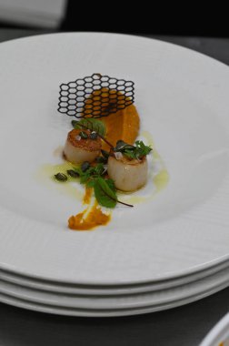 Kabak püresi, gurme aperatifi, bir restoranda beyaz tabakta servis edilen deniz tarakları, yakın çekim yemek fotoğrafçılığı, zarif bir yemek sunumu.,