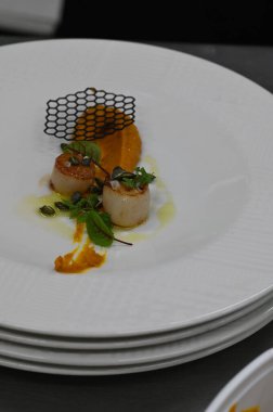 Kabak püresi, gurme aperatifi, bir restoranda beyaz tabakta servis edilen deniz tarakları, yakın çekim yemek fotoğrafçılığı, zarif bir yemek sunumu.,