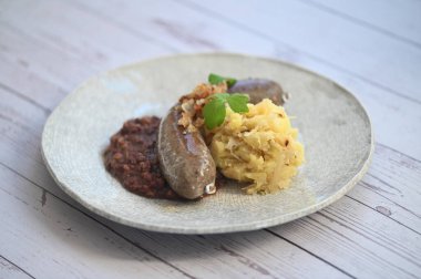 Geleneksel Çek mutfağının üst görüntüsü. Jitrnice ve jelita ile haşlanmış patates ve lahana turşusu servis ediliyor. Otantik Orta Avrupa yemekleri