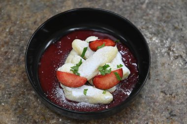 Patates köftesi tatlı olarak erik sosu, kuark ve taze meyve ile servis edilir. Geleneksel Orta Avrupa tatlı yemeği iştah açıcı ve kırsal bir tarzda sunulmaktadır..