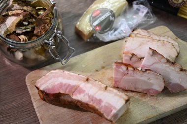 Domuz pastırması ve domuz eti ahşap bir masada sarımsak ve biberle