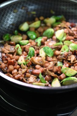 Sarımsaklı ve otlu kızarmış mantar. Açık bir tavada yemek pişirmek.