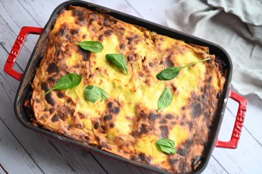 Gri masadaki fırın tabakasında lazanya.