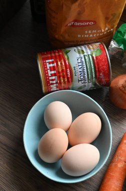 Bir kase taze yumurta ve mutfak masasında bir bardak su.