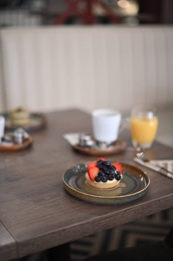 Böğürtlenli taze meyve keki ve masada kahve