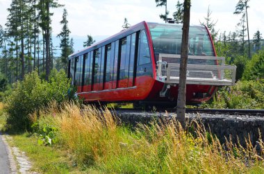 High Tatras 'ın panoramik manzaralı Star Smokovec' teki raylı demiryolu ve dağ treni. Görüntü, Tatras 'ın göbeğinde Slovakya' daki dağ manzarası ve manzaralı dağ zirveleriyle çevrili geleneksel dağ ulaşımını yakalıyor..