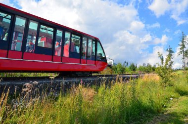 High Tatras 'ın panoramik manzaralı Star Smokovec' teki raylı demiryolu ve dağ treni. Görüntü, Tatras 'ın göbeğinde Slovakya' daki dağ manzarası ve manzaralı dağ zirveleriyle çevrili geleneksel dağ ulaşımını yakalıyor..