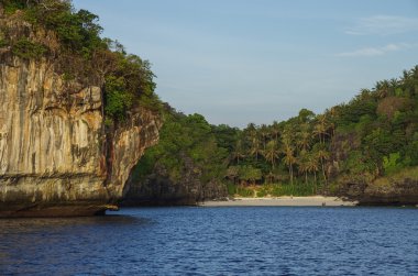 Hidden tropical beach and beautiful limestone cliffs around on s clipart