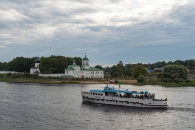 Pskov, Rusya - 22 Ağustos 2020: Mirozhsky Manastırı 'nın karşısındaki Velikaya nehrindeki eğlence teknesi. Spaso-Preobrazhensky Katedrali (12. yüzyıl) ve Stefanovskaya Kilisesi (17. yüzyıl)).