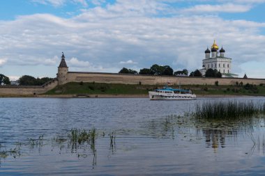 Pskov, Rusya - 21 Ağustos 2020: Pskov Krom 'daki Trinity katedralinin karşısındaki Velikaya nehrinde bir gezi teknesi (Kremlin).