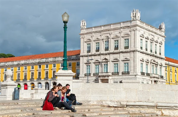 Merdiven üzerinde Commerce Square Tagus Nehri üzerinde oturan genç insanlar