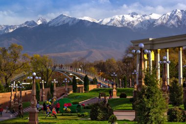 İnsanlar dağların manzarasına sahip bir parkta yürüyüş