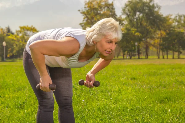 Starsza Kobieta Jest Zaangażowana Fitness Hantlem Trybie Izolacji Zewnątrz Parku — Zdjęcie stockowe