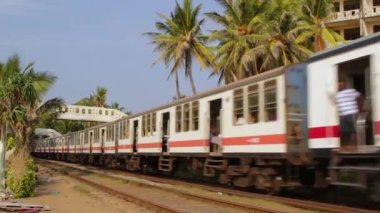 Colombo, Sri Lanka - 12 Ocak 2018. Açık kapılı geleneksel Sri Lanka treni ve yolcu yatağı istasyondan geçiyor.