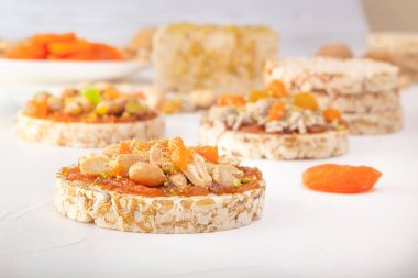 Fıstıklı patlamış buğday taneleri ve kayısı ezmesi ince bir tabaka kayısı reçeli beyaz ahşap bir masada doğu tatlılarının arka planında.