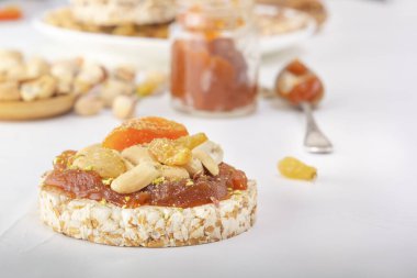 Fıstıklı patlamış buğday taneleri ve kayısı ezmesi ince bir tabaka kayısı reçeli beyaz ahşap bir masada doğu tatlılarının arka planında.