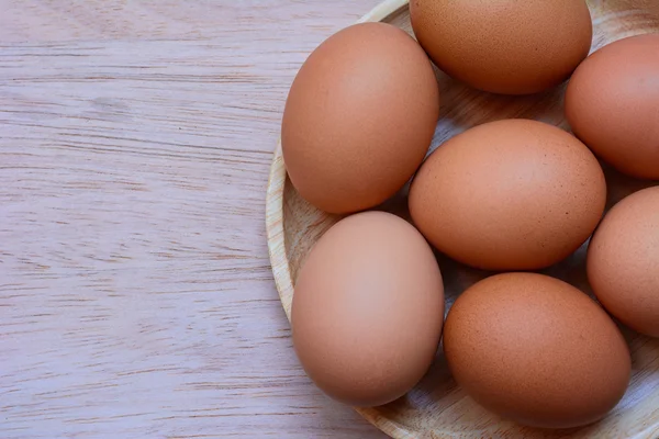 Huevos en plato sobre fondo de madera Imágenes de stock libres de derechos