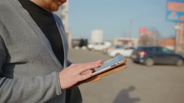 Detail člověka, který čte zprávy na tabletu a náklady na ulici. — Stock video