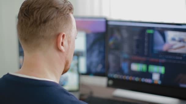 De man de programmeur werkt op de computer en drie monitoren — Stockvideo