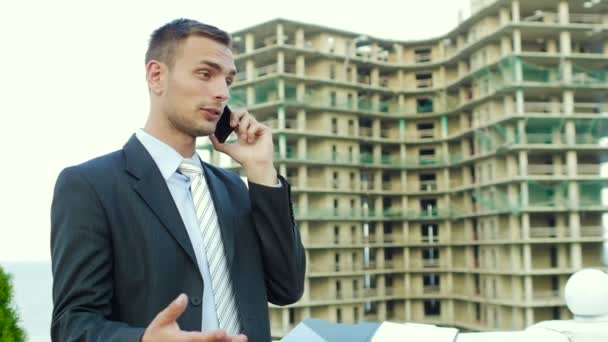 Επιχειρηματίας αρχιτέκτονας μιλάει στο τηλέφωνο, ενώ στέκεται δίπλα στο νέο κτίριο — Αρχείο Βίντεο