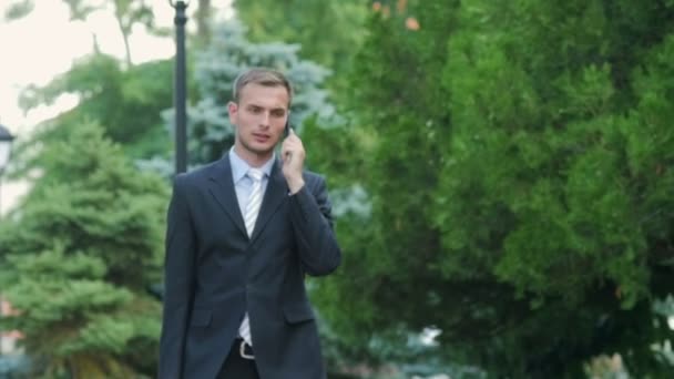 Jeune homme d'affaires prospère parlant au téléphone — Video