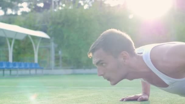 Спортсмен тренируется на детской площадке под открытым небом — стоковое видео
