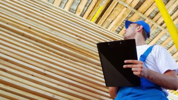 Young worker making an inventory of stock on wood — Stock Video