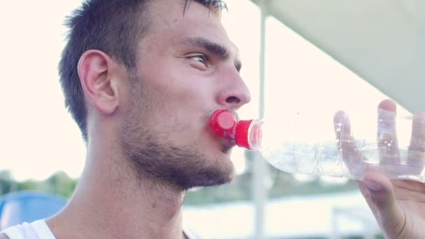 Cansado de entrenar el atleta se sienta en un banco — Vídeos de Stock