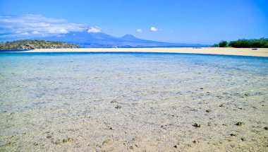 Dağın arka planında ve berrak gökyüzünde güzel bir kumsal manzarası.