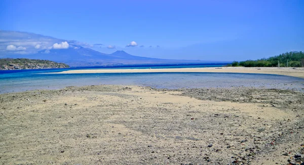 Dağın arka planında ve berrak gökyüzünde güzel bir kumsal manzarası.
