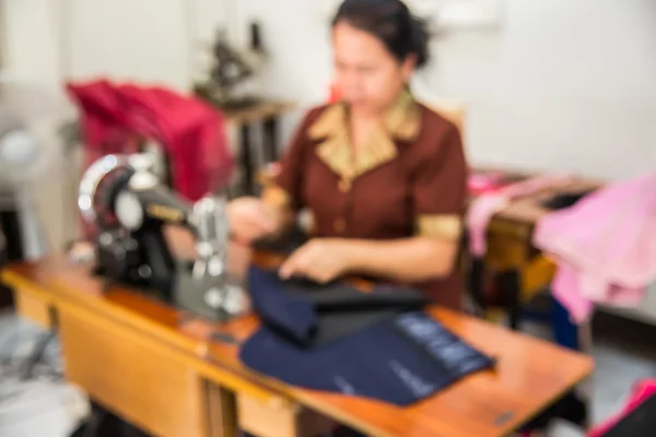 Imagem turva de costureira trabalhando na máquina de costura — Fotografia de Stock