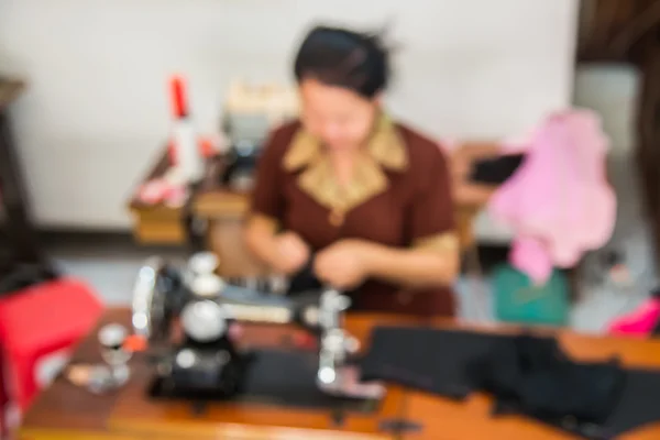 Imagem turva de costureira trabalhando na máquina de costura — Fotografia de Stock