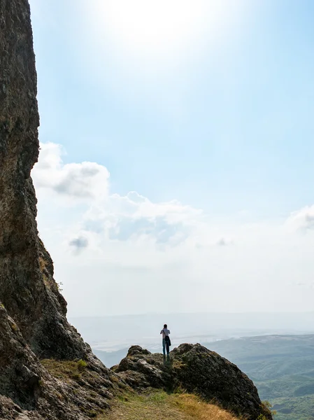 man on the edge of a cliff in the mountains