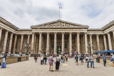 Büyük sütunları, pedikürleri ve dramatik bir gökyüzü altında hareketli turistik aktiviteleri olan İngiliz Müzesi 'nin ikonik ön cephesi. Londra, İngiltere, 27 Haziran 2023