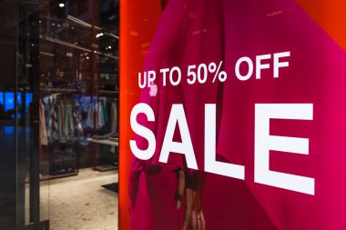 Canlı pembe mağaza vitrininde bir butik vitrininde yüzde 50 'ye kadar indirimli pankart var..