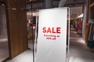 Modern giyim mağazasının içinde kırmızı bir satış sergisi var..