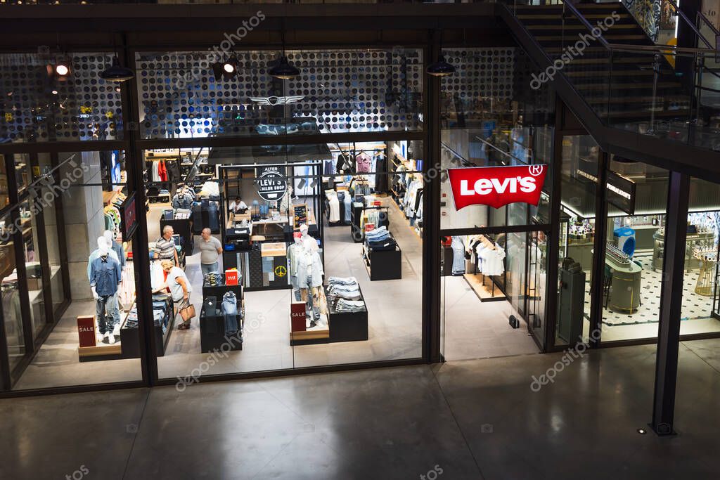 Contemporary jeans boutique featuring branded signage, apparel racks, and neatly arranged denim, captured from outside a Levis store in an urban mall. London, UK, 4 July 2023