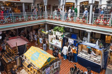 Londra 'daki Camden Market' in yüksek açılı manzarası, alışveriş yapanlar ve yiyecek tezgahlarıyla dolu. Çok katlı balkonlar, esnaf satıcıları ve canlı bir şehir atmosferi. Londra, İngiltere, 8 Temmuz 2023