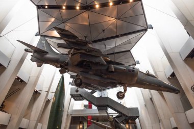 Londra İmparatorluk Savaş Müzesi 'nin iç manzarasında avluda askıya alınmış bir savaş jeti ve askeri eserler dramatik mimaride yer alıyor. Londra, İngiltere, 9 Temmuz 2023