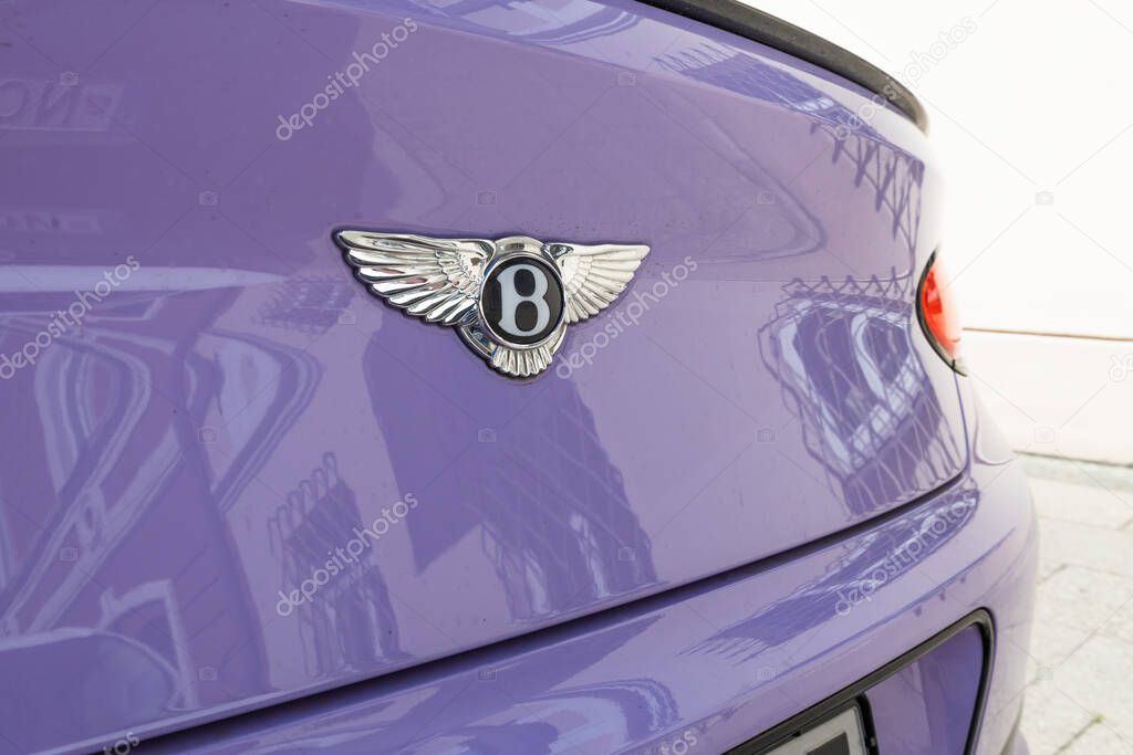 Close view of a luxury car trunk with Bentley badge on violet paint, highlighting refined materials and finish. Vilnius, Lithuania, 2 July 2025