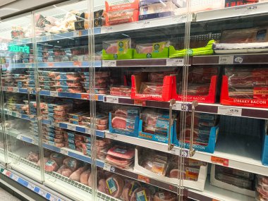 Açık süpermarket dondurucu koridoru paketli dondurulmuş gıdalar, açık fiyat etiketleri ve market alışverişi için organize perakende rafları. Londra, İngiltere, 15 Nisan 2024